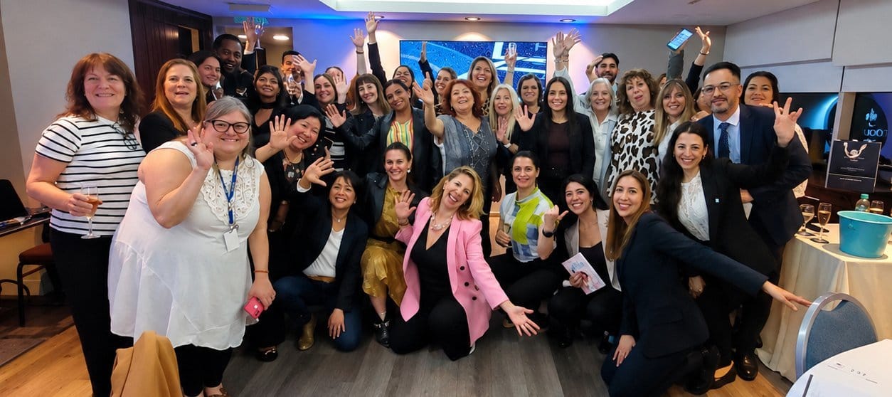 Ani con blazer rosa, en el centro de un grupo grande de mujeres celebrando en un evento