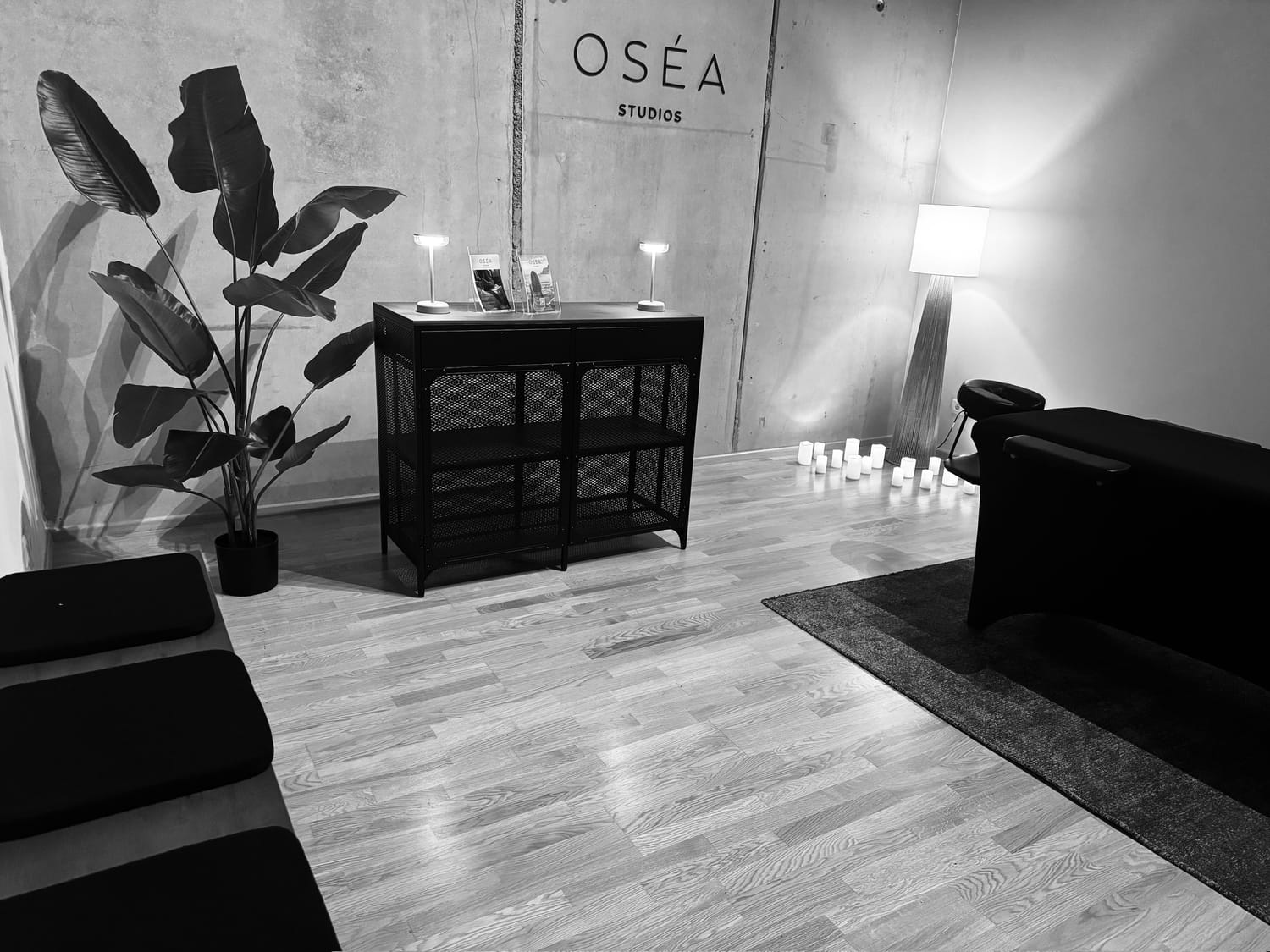 Oséa Studios Mainz – Maderotherapie Studio Innenansicht Wellness Studio Mainz mit Betonwand und Kerzenatmosphäre Massage Studio in Mainz – Oséa Studios Empfangsbereich Ruhiger Behandlungsraum für Maderotherapie in Mainz Holzmassage Studio Mainz – Oséa Studios Atmosphäre Sanftes Wellness Studio für Frauen in Mainz Oséa Studios – Ort für Entspannung und Erholung in Mainz