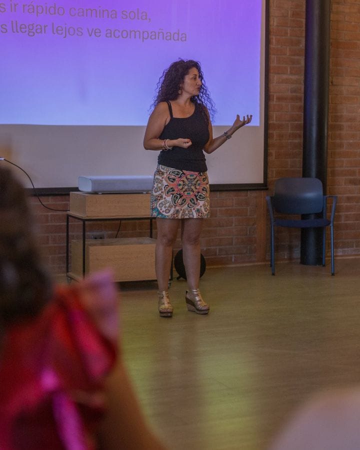 Marianella Ruiz hablando frente a una pantalla en una charla