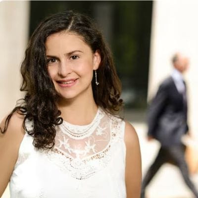 Marcela Ramírez, psicóloga organizacional, con una blusa blanca de encaje, sonriendo
