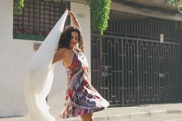 Marianella Ruiz bailando en la calle con una tela blanca al viento