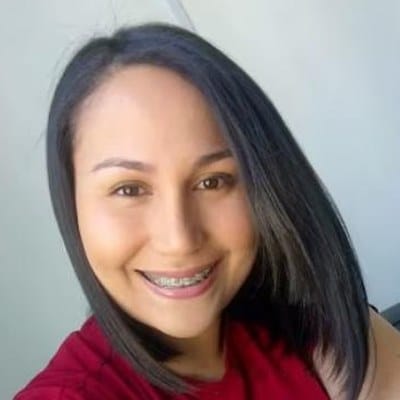 Antonella Peña, estudiante de psicología, sonriendo con polera roja
