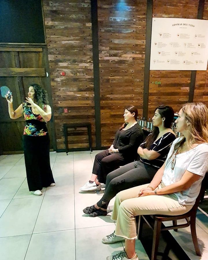 Marianella Ruiz dando un taller a un grupo de mujeres sentadas