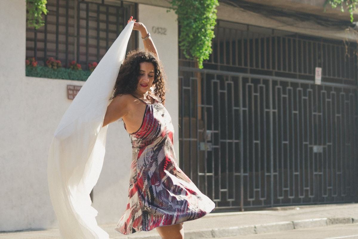Marianella Ruiz bailando en la calle con una tela blanca al viento