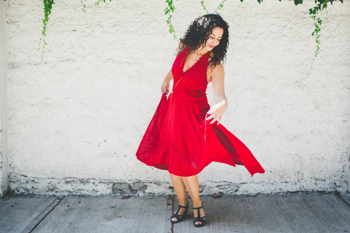 Marianella Ruiz con un vestido rojo, girando con la falda al viento