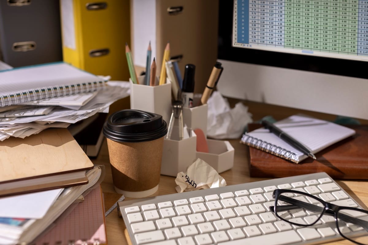 vue d'un bureau avec un espace de travail chargé et un ordinateur