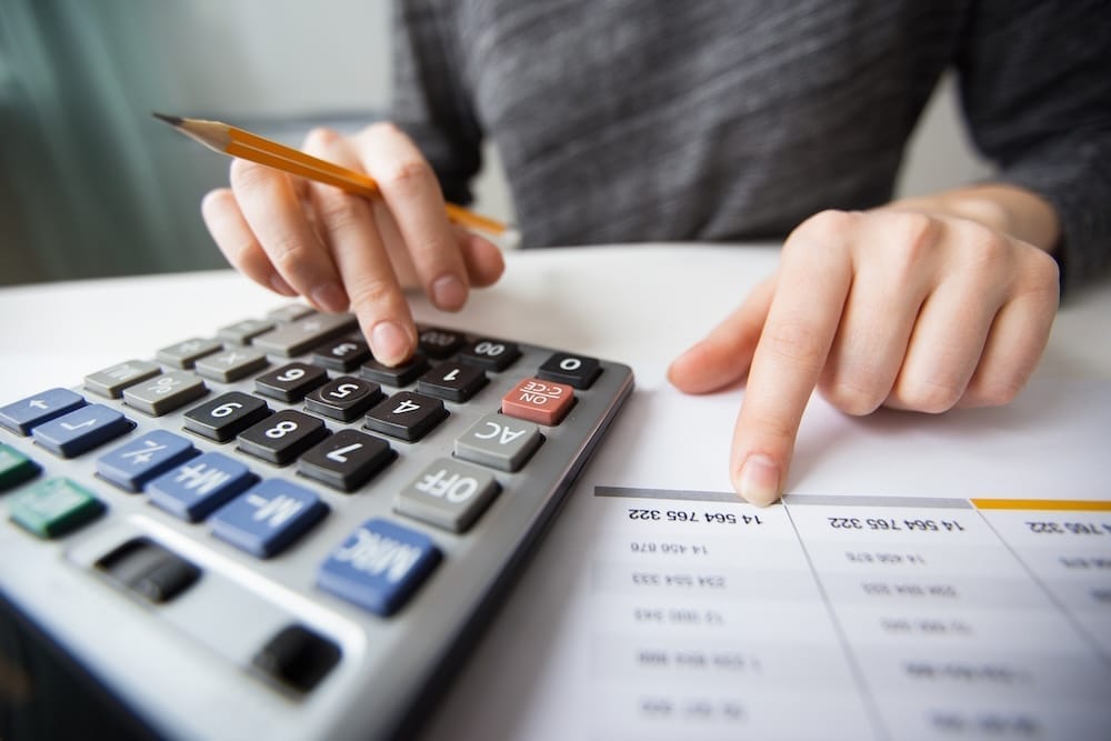 gros plan sur les mains d'une personne utilisant une calculatrice