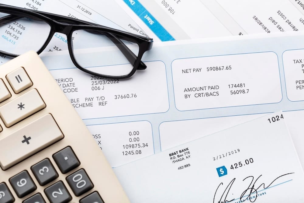 Documents empilés avec calculatrice et lunette dessus