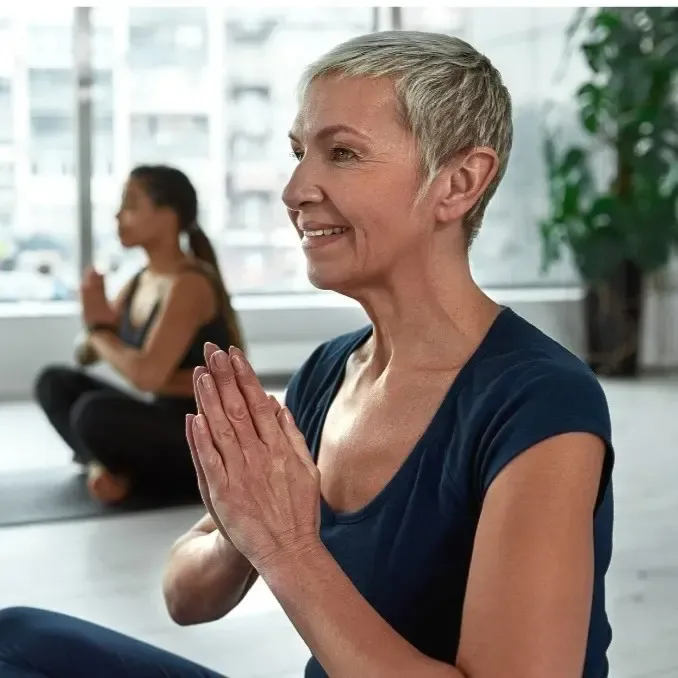 A woman over 50 practicing gentle yoga for emotional healing and physical vitality.