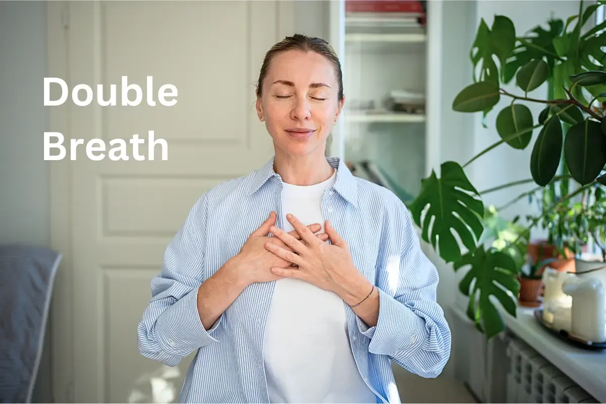 Woman over 50 with eyes closed, demonstrating the physiological sigh breathing technique for instant stress relief and emotional well-being.