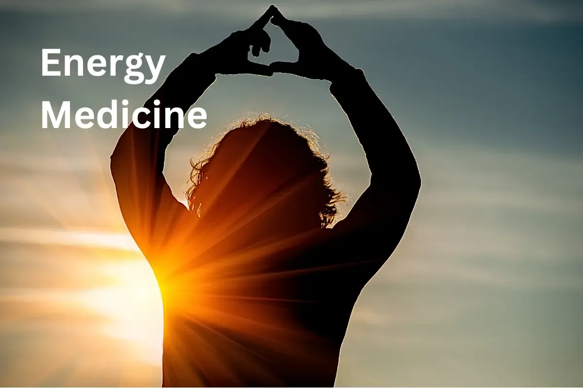 Woman over 50 watching a golden sunrise to boost her natural energy medicine and vitality.