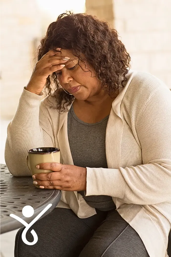 A middle-aged looking anxious, being unhappy with her responses to others.