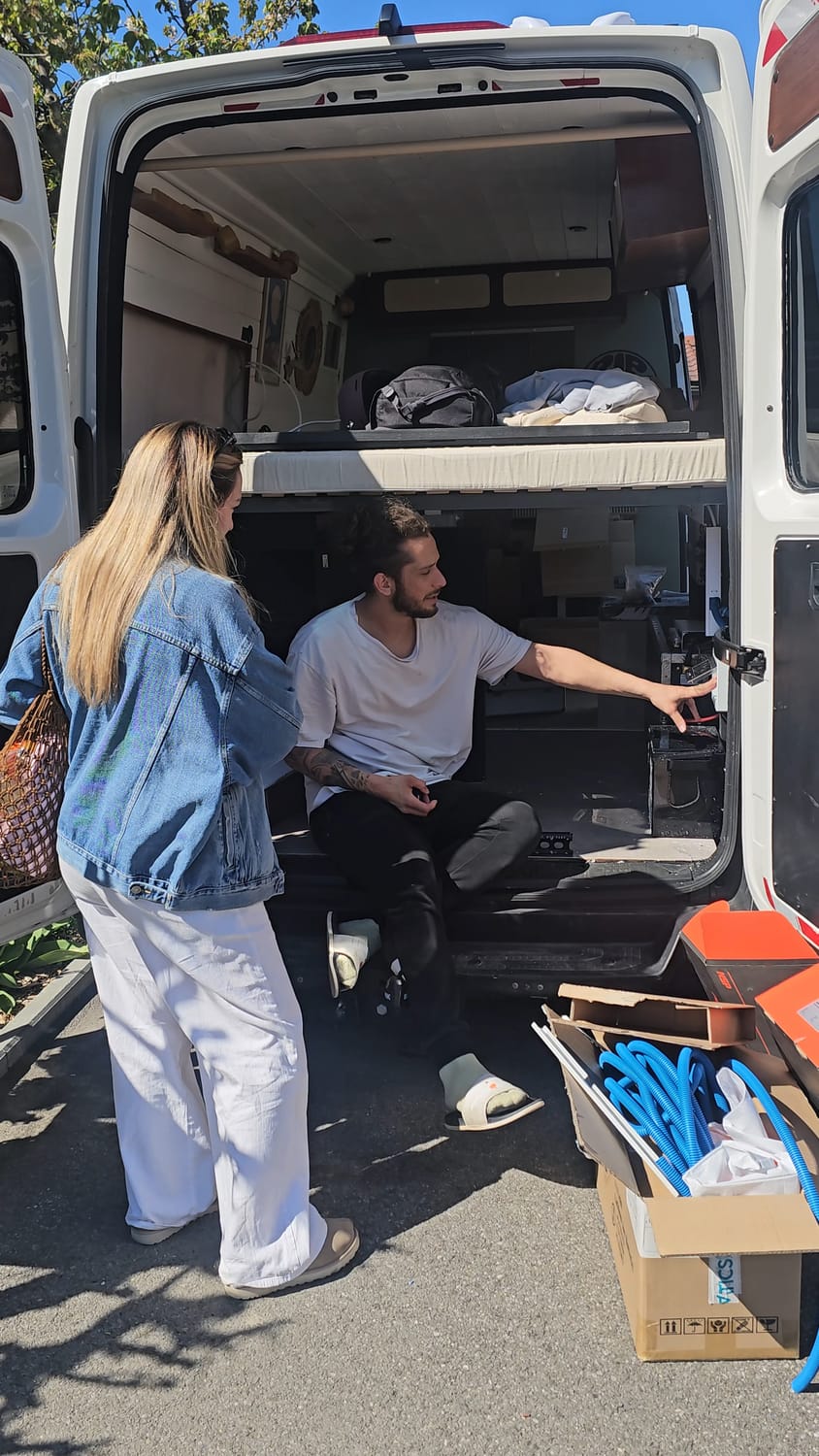 Gaël conseille une cliente devant l'installation électrique de son van