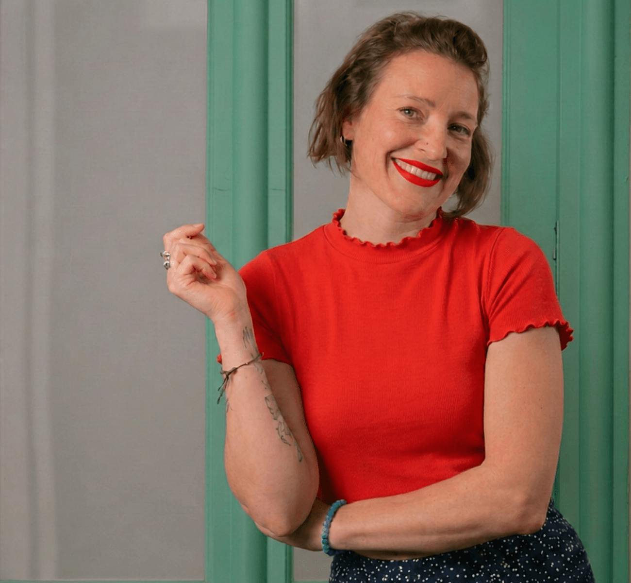 Professional headshot of Hannah, a smiling woman with short brown hair standing in a doorway