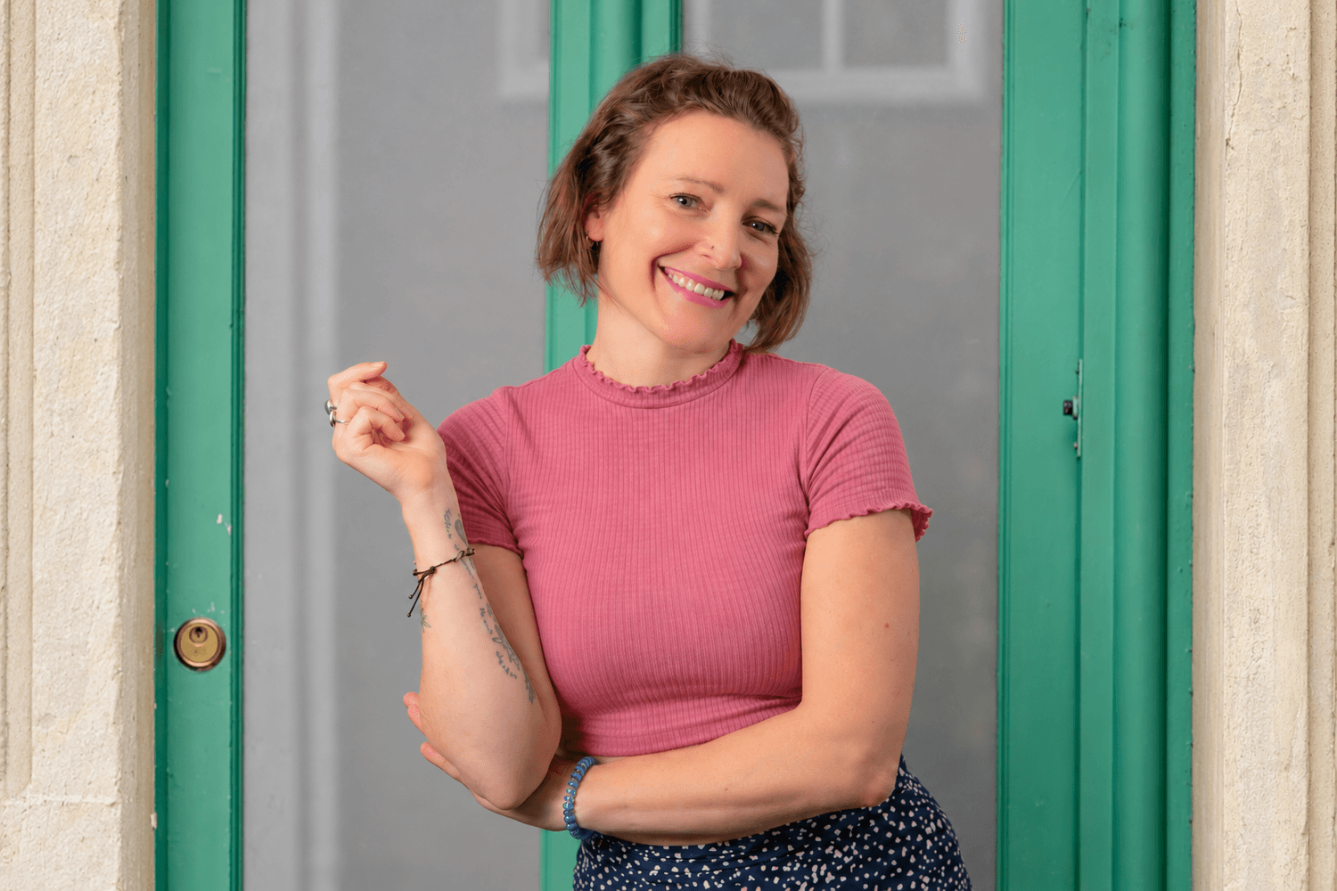 Professional headshot of Hannah, a smiling woman with short brown hair standing in a doorway