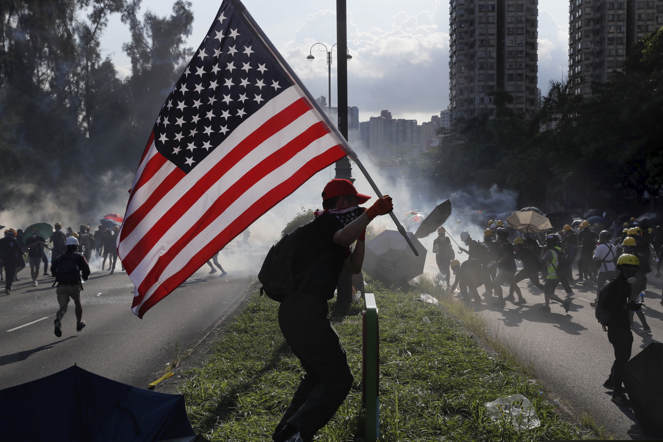 American flag with protestors.