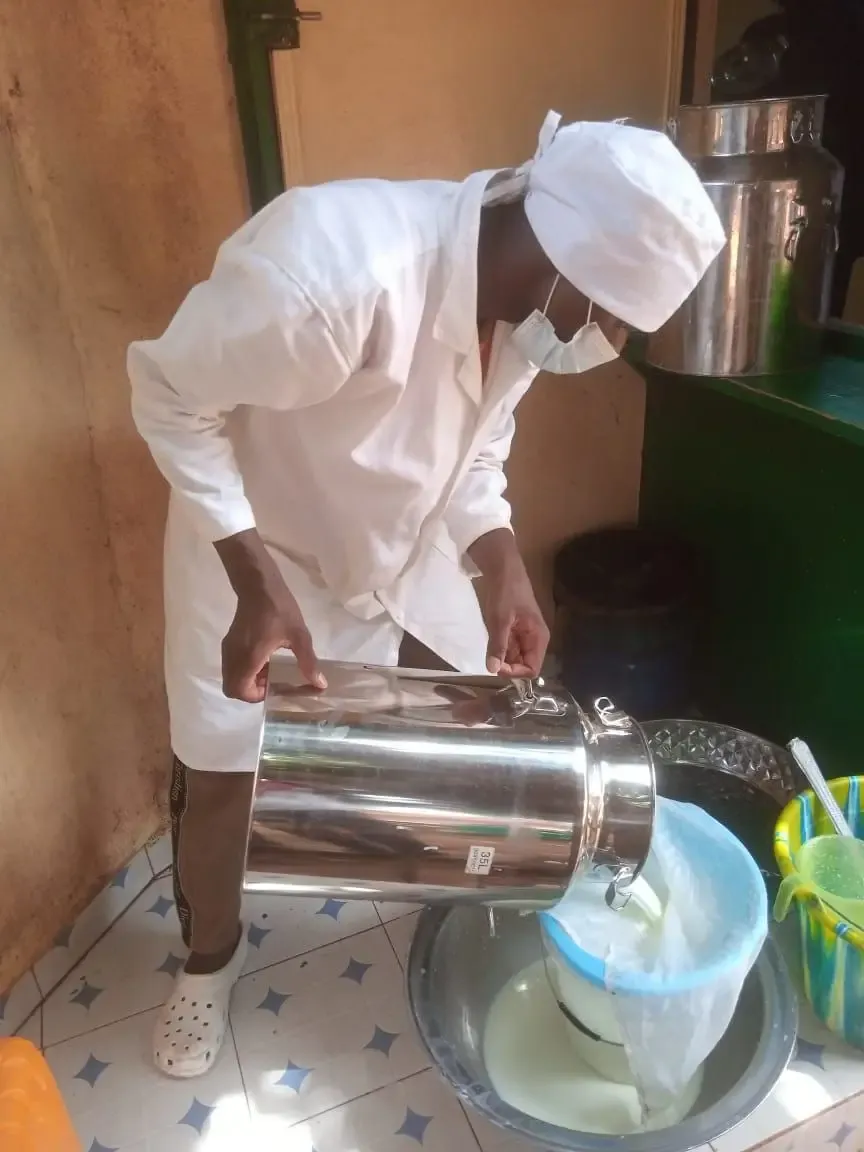 L’image montre un technicien qui procède au tamisage du lait.
