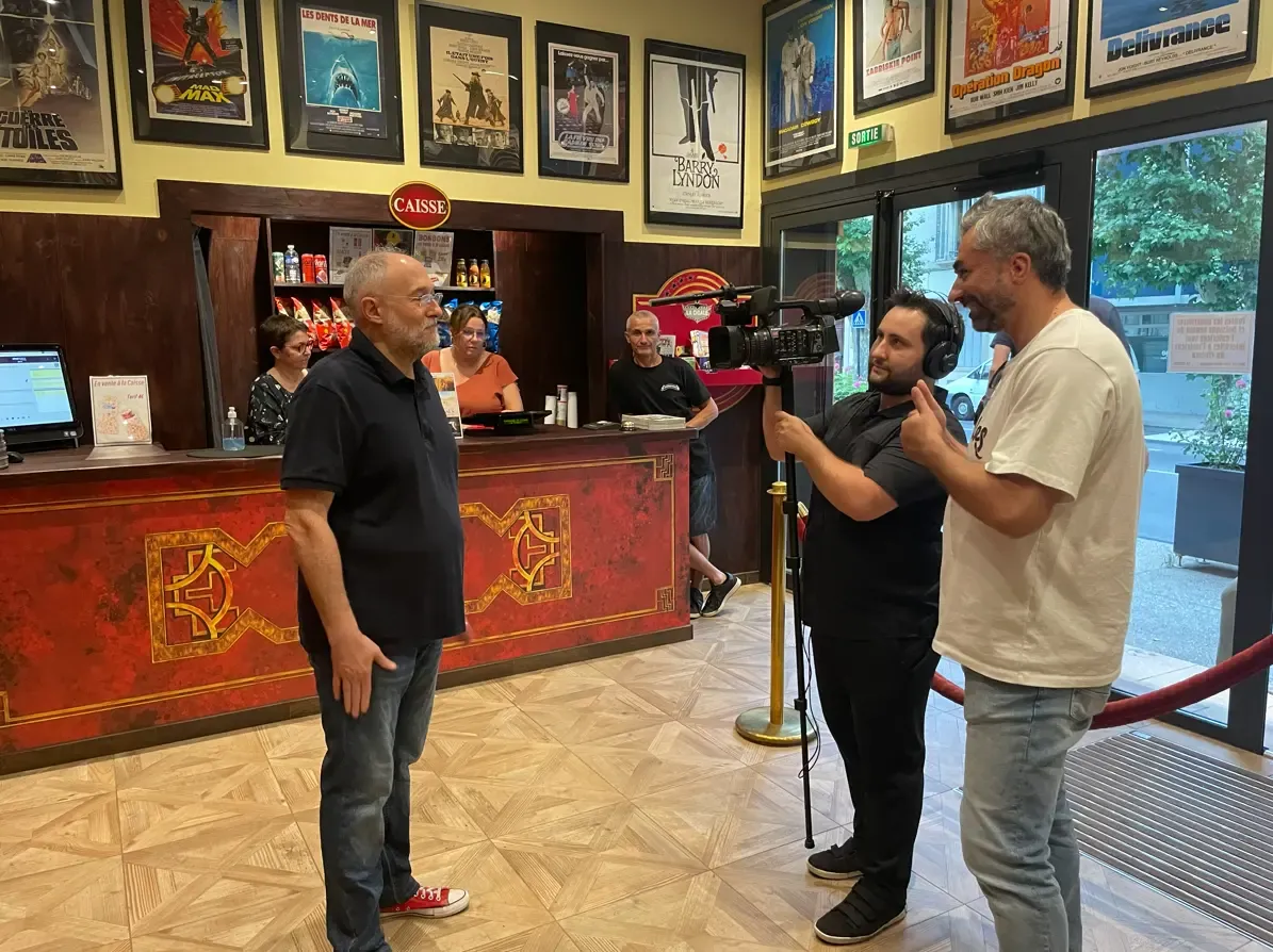 Équipe et matériel dans les coulisses d’un cinéma indépendant pendant le tournage de Derrière le rideau