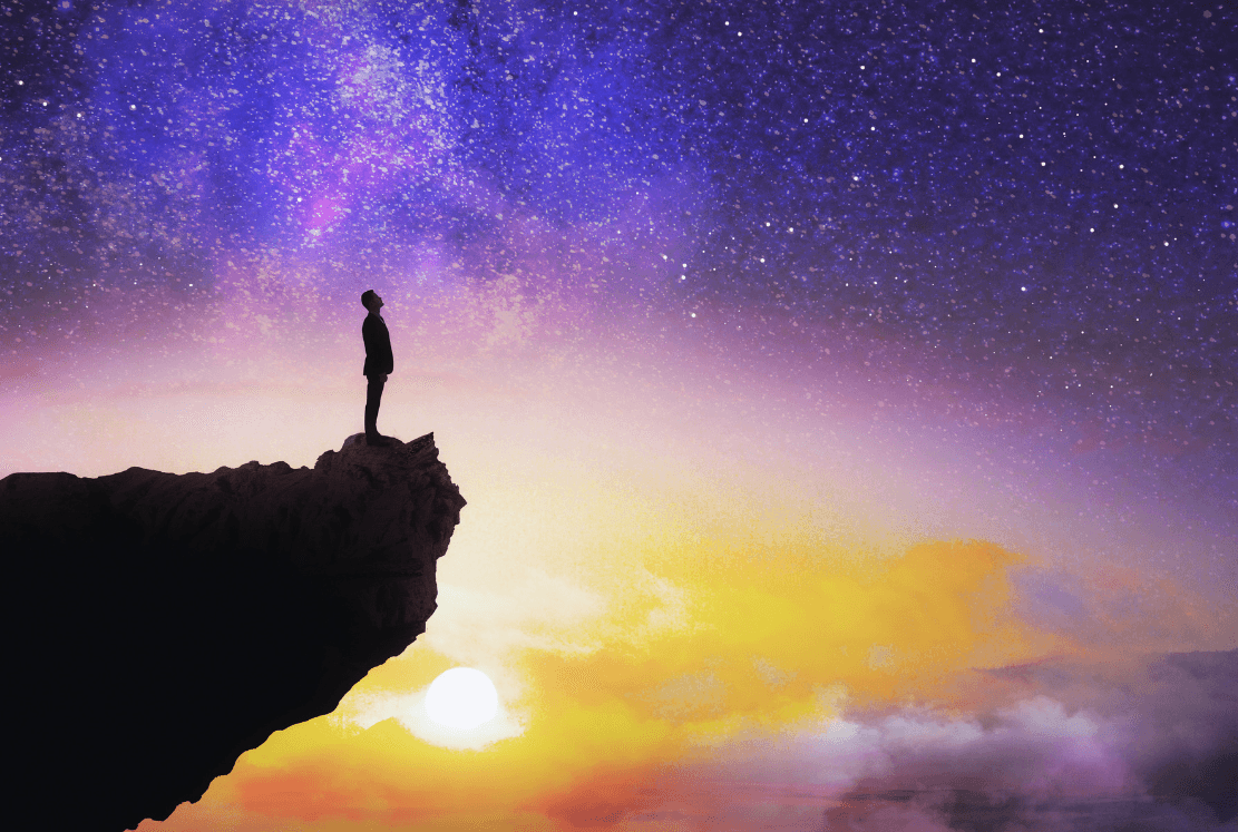 A person standing at sunset on a cliff. Emotion: Freedom, peace, lightness.