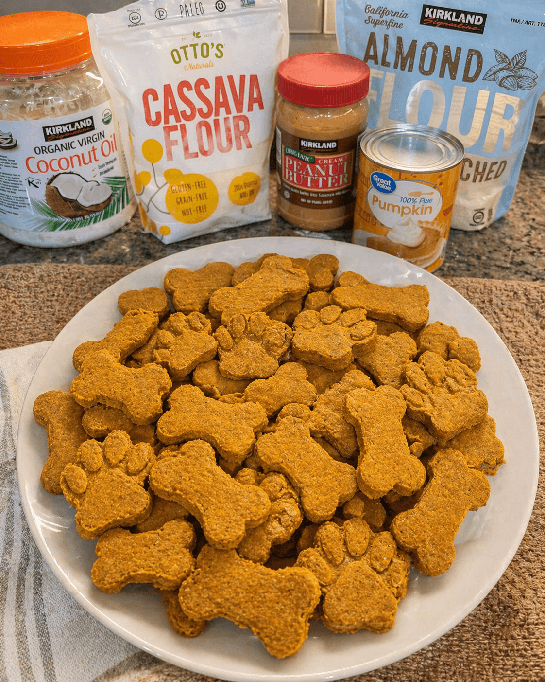 Homemade dog biscuits in bone and paw shapes on a white surface