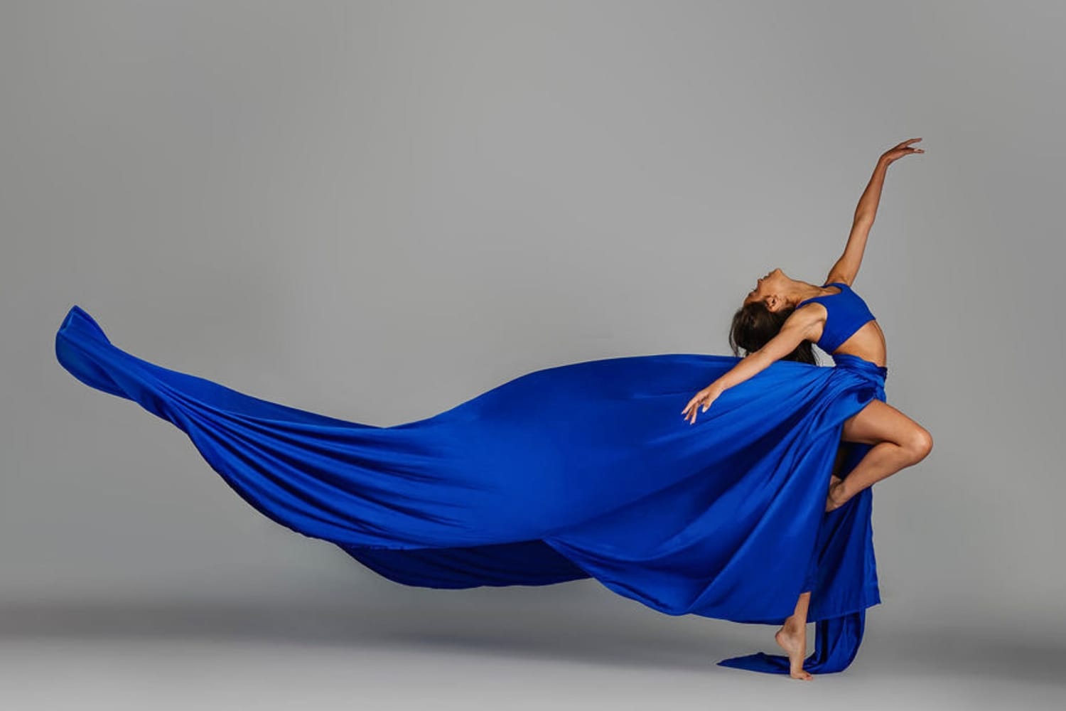 Vanessa Fox performing an expressive contemporary dance pose with flowing blue fabric in a studio portrait.
