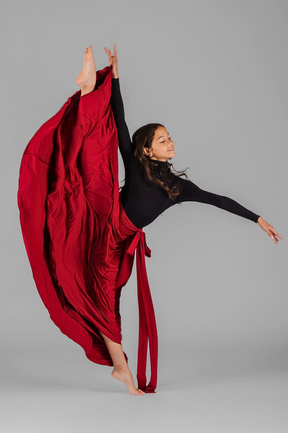 Vanessa Fox in a dramatic contemporary dance pose wearing flowing red fabric in an editorial portrait.