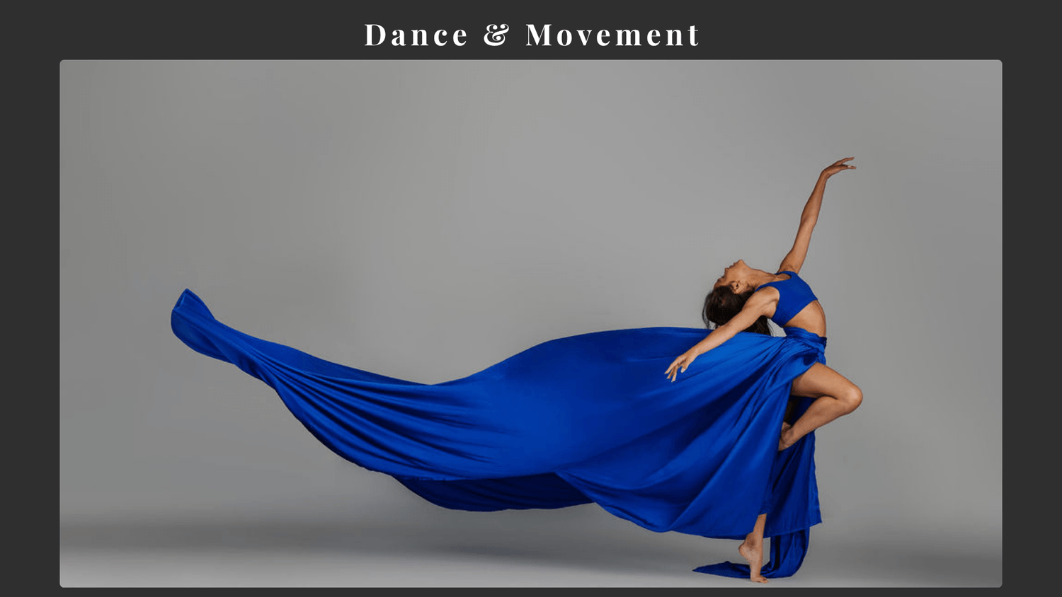 Vanessa Fox performing an expressive dance pose with flowing blue fabric
