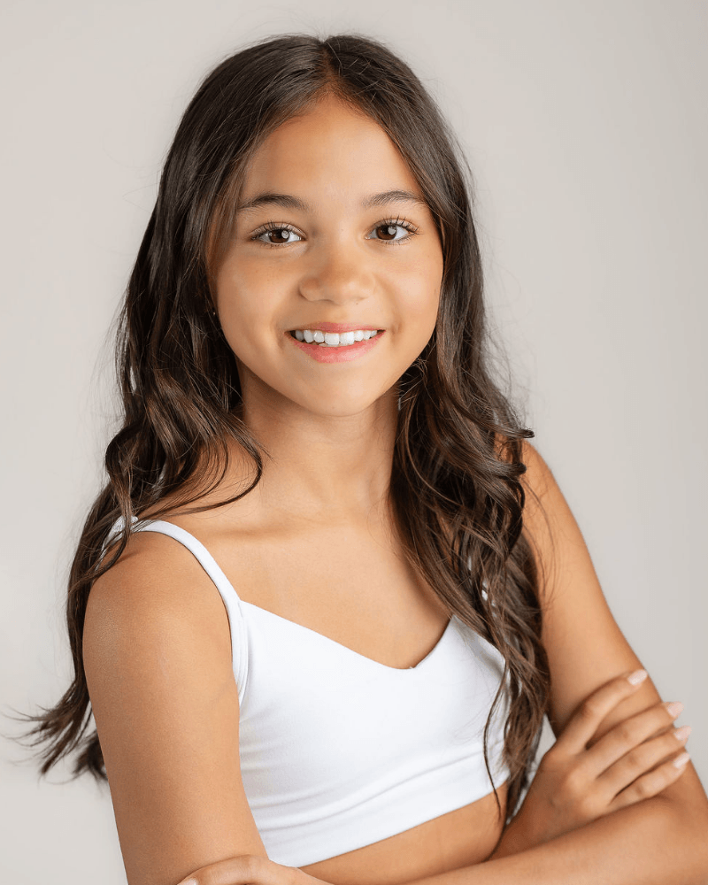 Portrait of Canadian teen actress Vanessa Fox smiling in a white top.