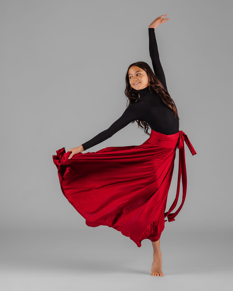 Vanessa fox performing an expressive dance movement with a flowing red skirt.
