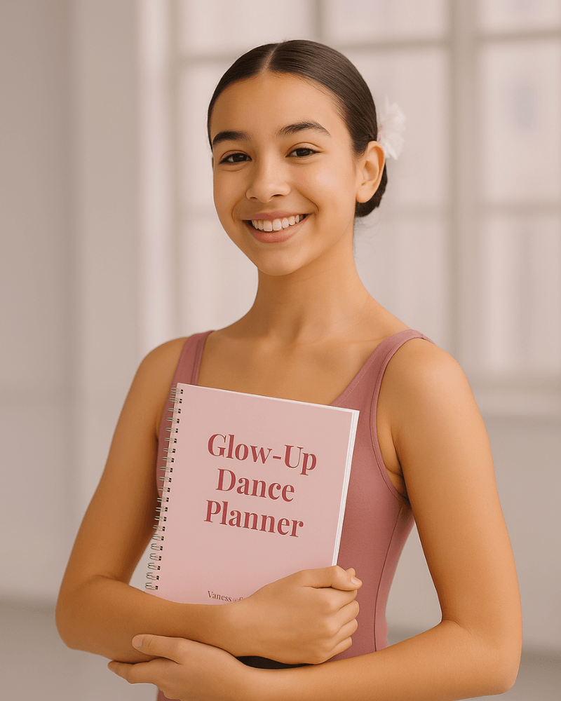 A smiling young dancer in pink dancewear holding a Glow-Up Dance Planner for organizing training, goals, and competitions.