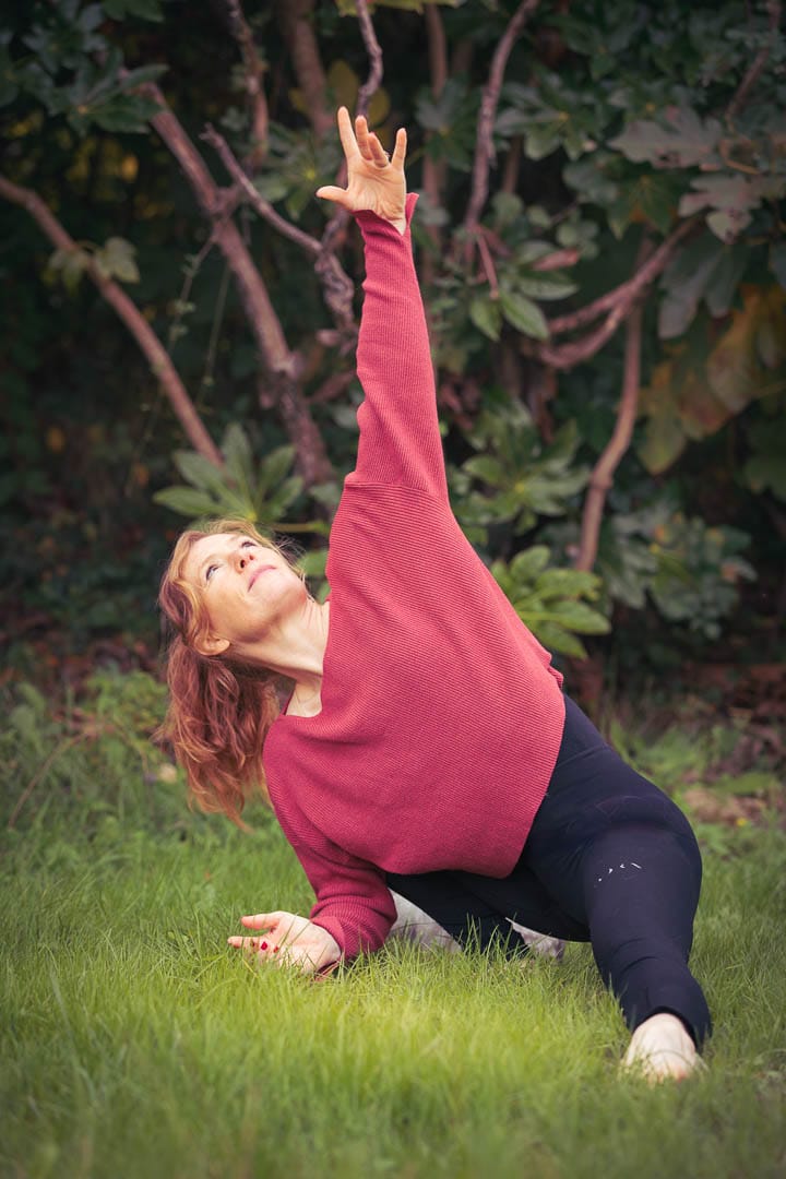Femme en posture de danseuse, mouvement fluide, dans un jardin
