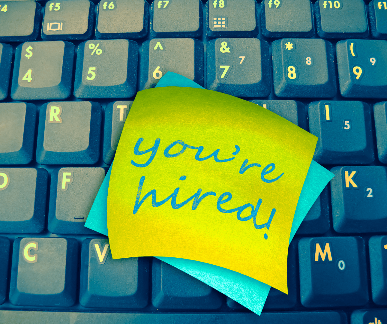Keyboard with "you're hired" sticky notes
