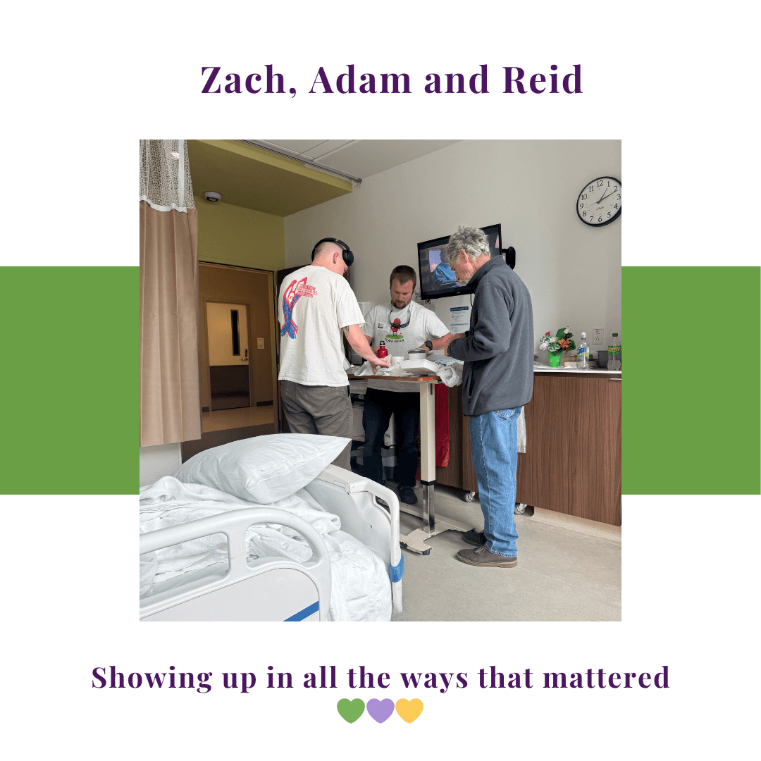 Three men gathered around a hospital tray table in a patient room, offering support during recovery