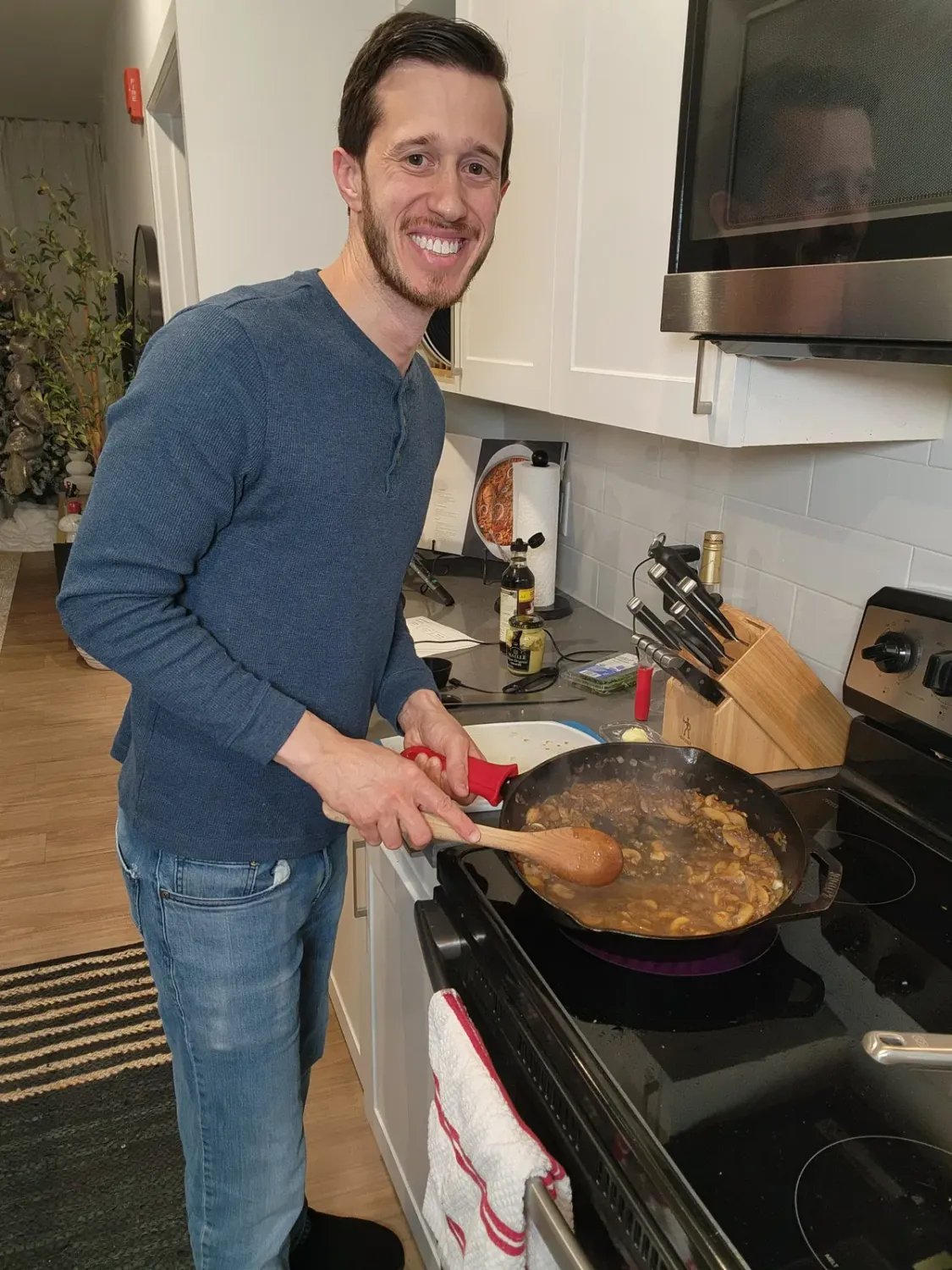 Patrick cooking at the stove smiling