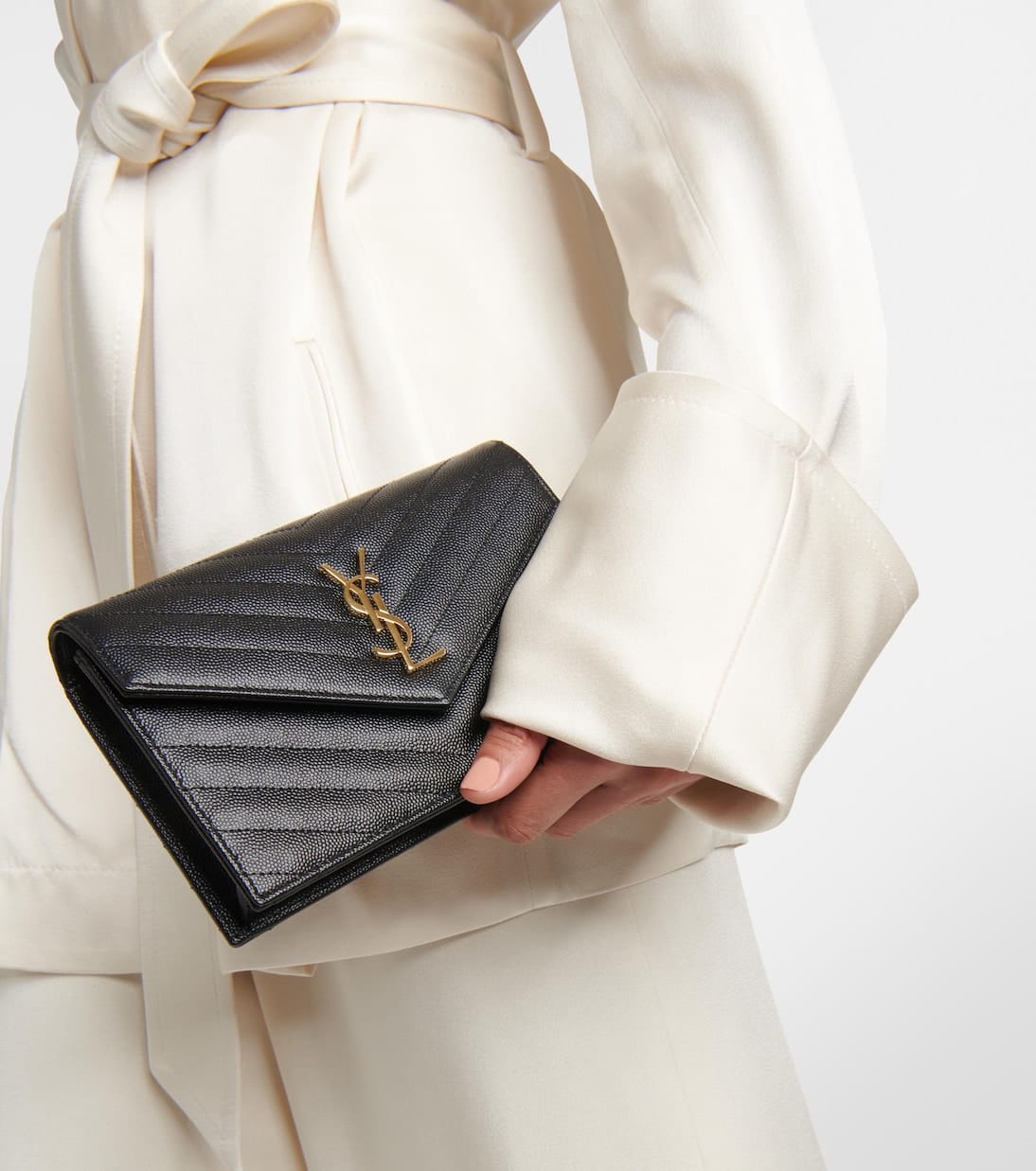 Luxury fashion editorial – black designer clutch styled in a minimalist ivory outfit, AECREATIV visual curation