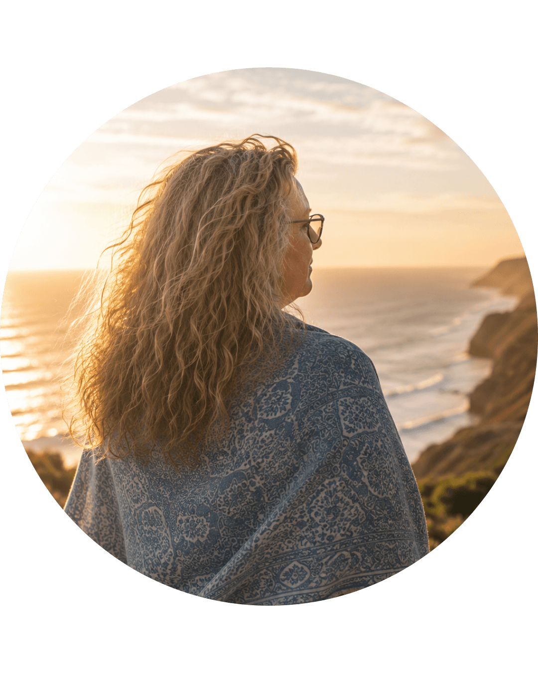 Nicol Heard wrapped in a patterned shawl, looking out over the Surf Coast at sunset.