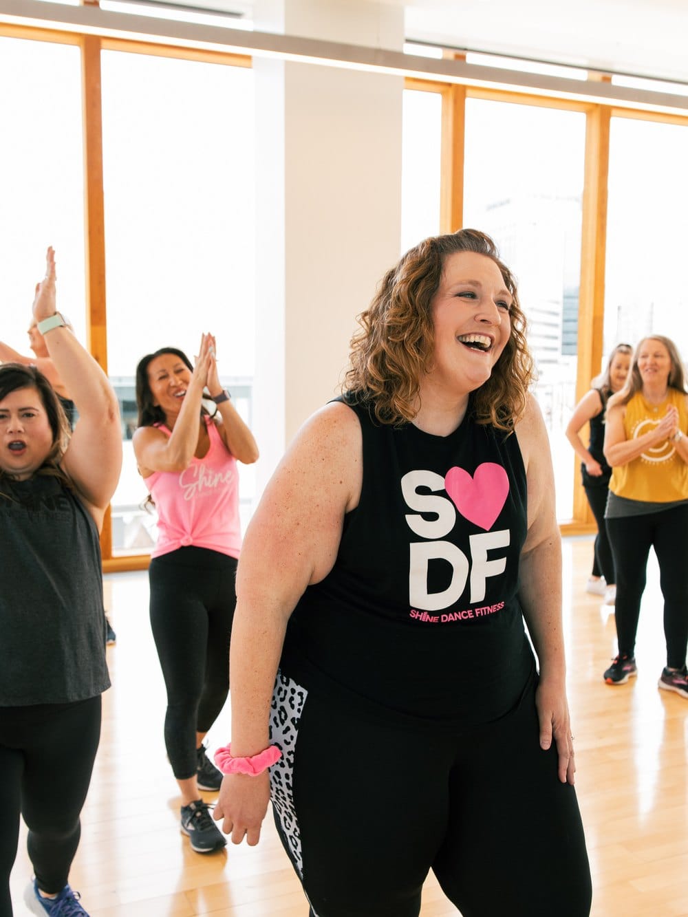 Teilnehmerin lacht während einer SHiNE Dance Fitness Stunde