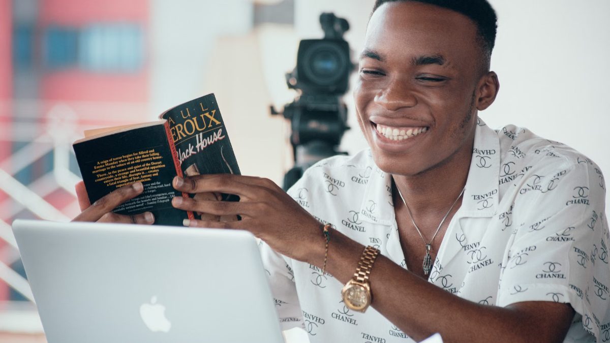 Un homme souriant lit un livre