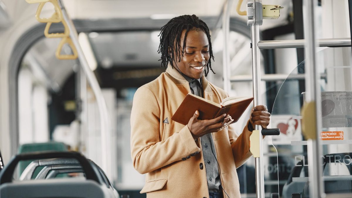 Un homme souriant lit un livre