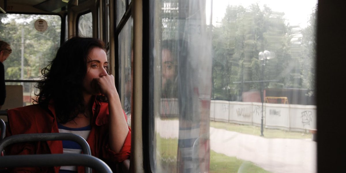 Une femme réfléchit, le regard vers la fenêtre