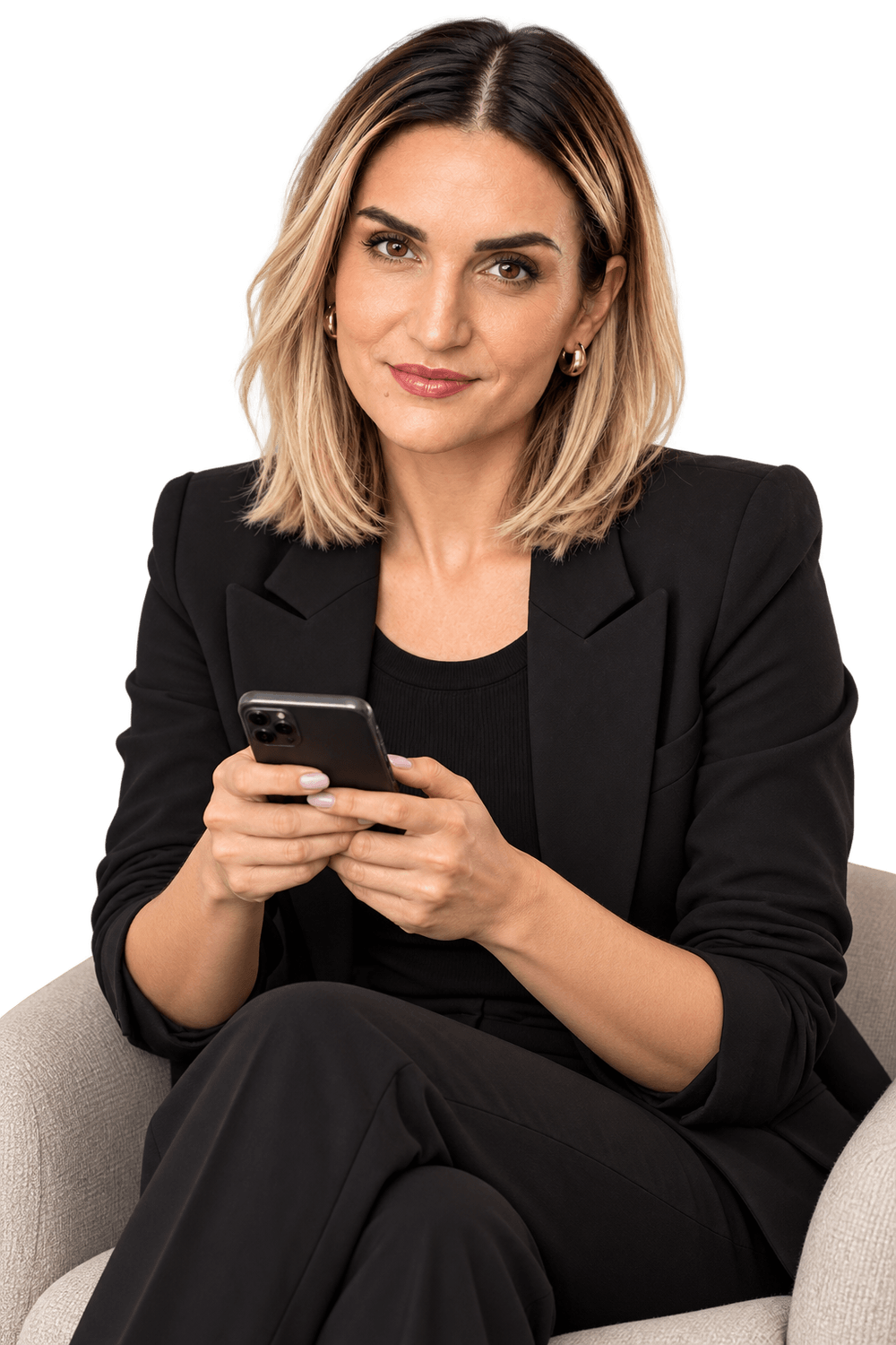 Charline Caron assise dans un fauteuil avec son téléphone.
