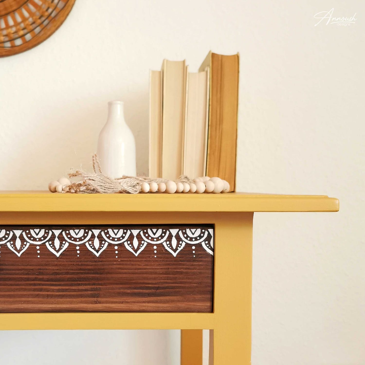 Detailansicht auf die seitliche Front eines Boho Beistelltischs, das im Farbton "Golden Hour", einem gedeckten wunderschönen Goldgelbton, gestrichen wurde. Dekoriert ist die Oberfläche mit zwei Glaskaraffen.