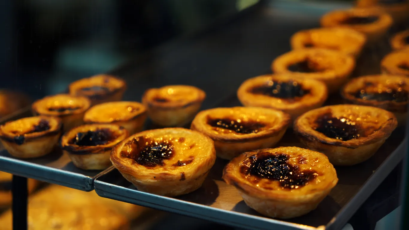 Pastéis de Nata em uma bandeja, polvilhados com canela.