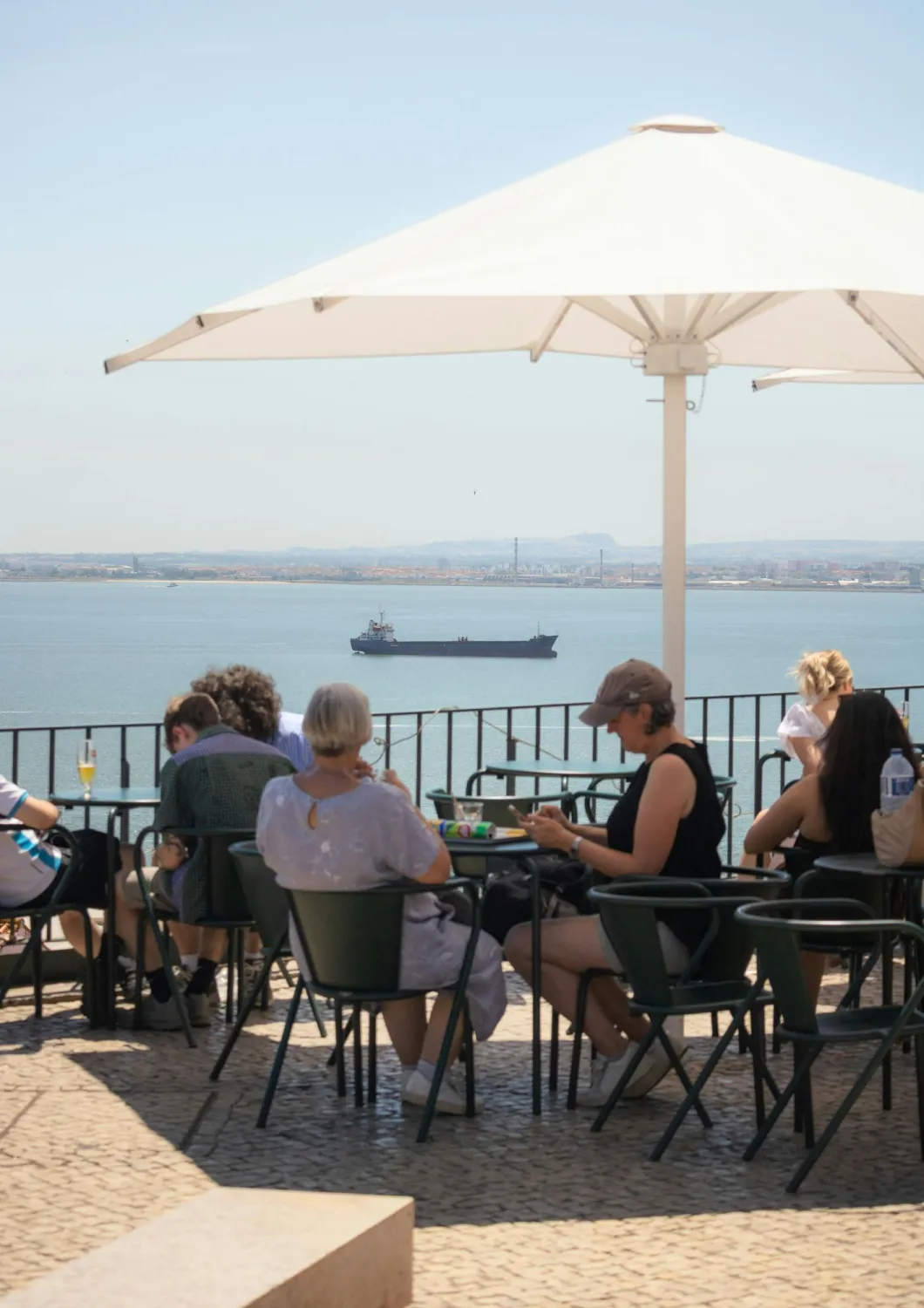 imagem mostra uma opção de roteiro para uma experiência gastronômica em lisboa em um restaurante com vista para o rio tejo