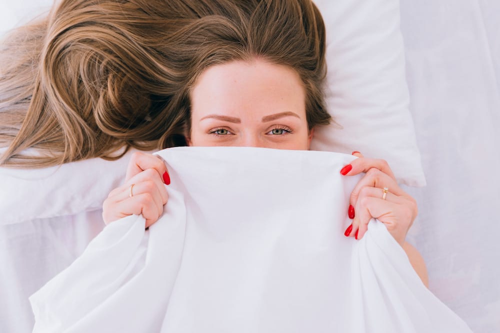 un pied qui sort de la couette pour aider à s'endormir grâce à la thermorégulation