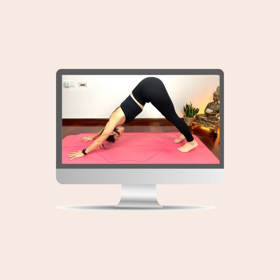 Inés en postura de perro boca abajo durante una clase de yoga online en directo por Zoom para personas con molestias digestivas.