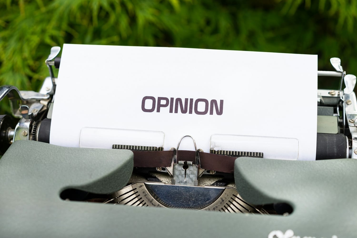 Close-up of a vintage typewriter with a sheet of paper displaying the word “OPINION,” symbolizing editorial writing, commentary, and media literacy.