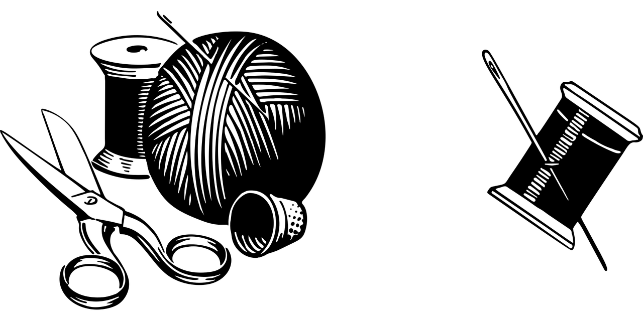 Ompelijan työvälineet, neula, lanka ja sakset valmiina käsityöhön