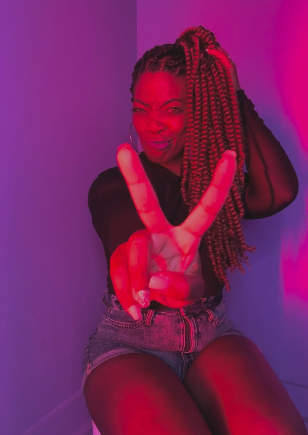 Kala C. Simmons, MSW | Confidence & Authenticity Coach, Visionary Founder & CEO of The Kollective, Sitting extending the peace sign