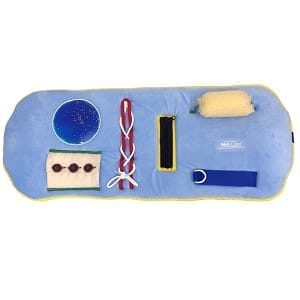 Skil-Care Activity Tray Overlay used as a fidget blanket for dementia patients, with tactile elements like zippers, laces, and beads placed over a wheelchair tray